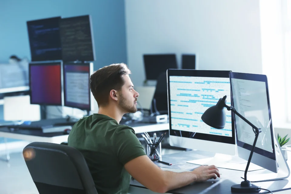 D&eacute;veloppeur Python travaille du code sur plusieurs &eacute;crans d'ordinateur