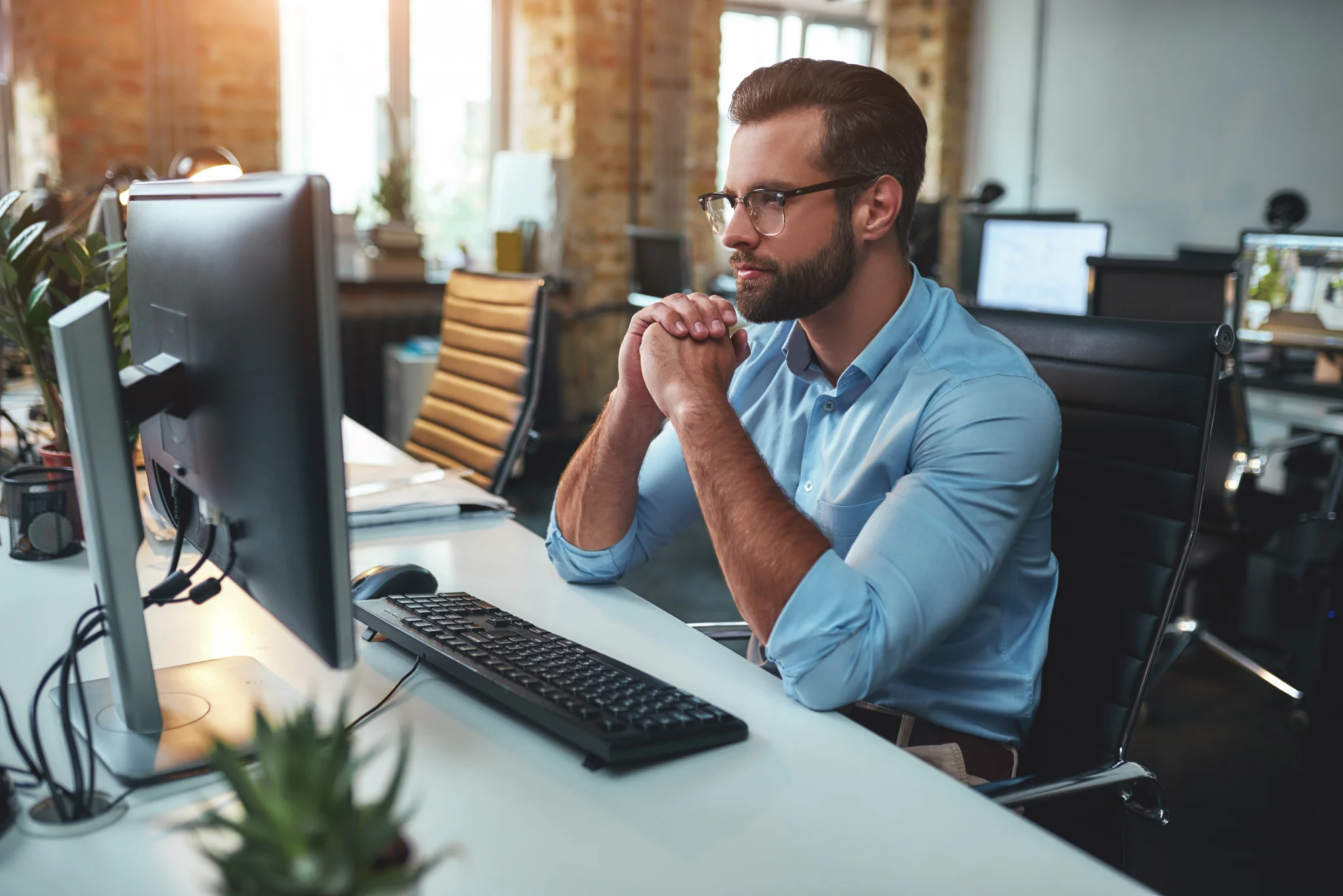 Homme qui r&eacute;fl&eacute;chit devant son ordinateur