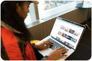 Femme sur son ordinateur portable regardant le catalogue de cours en ligne talenteed avec une vue sur la ville